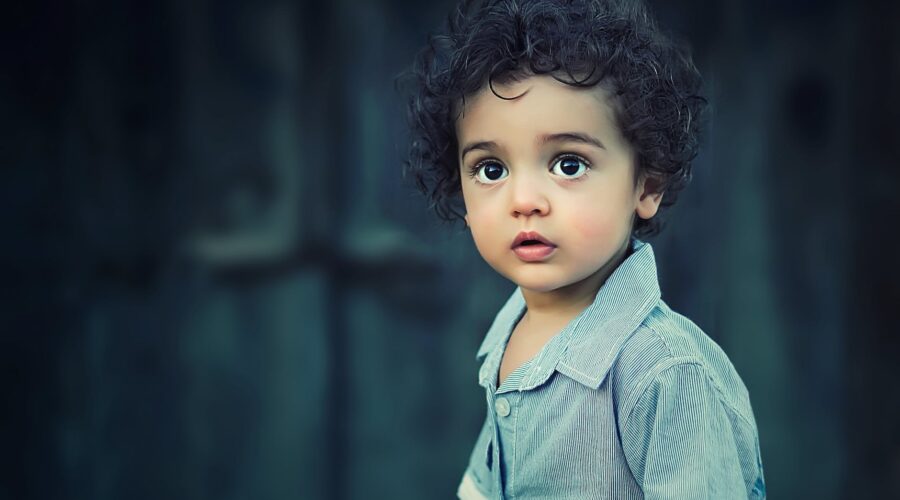 toddle wearing gray button collared shirt with curly hair