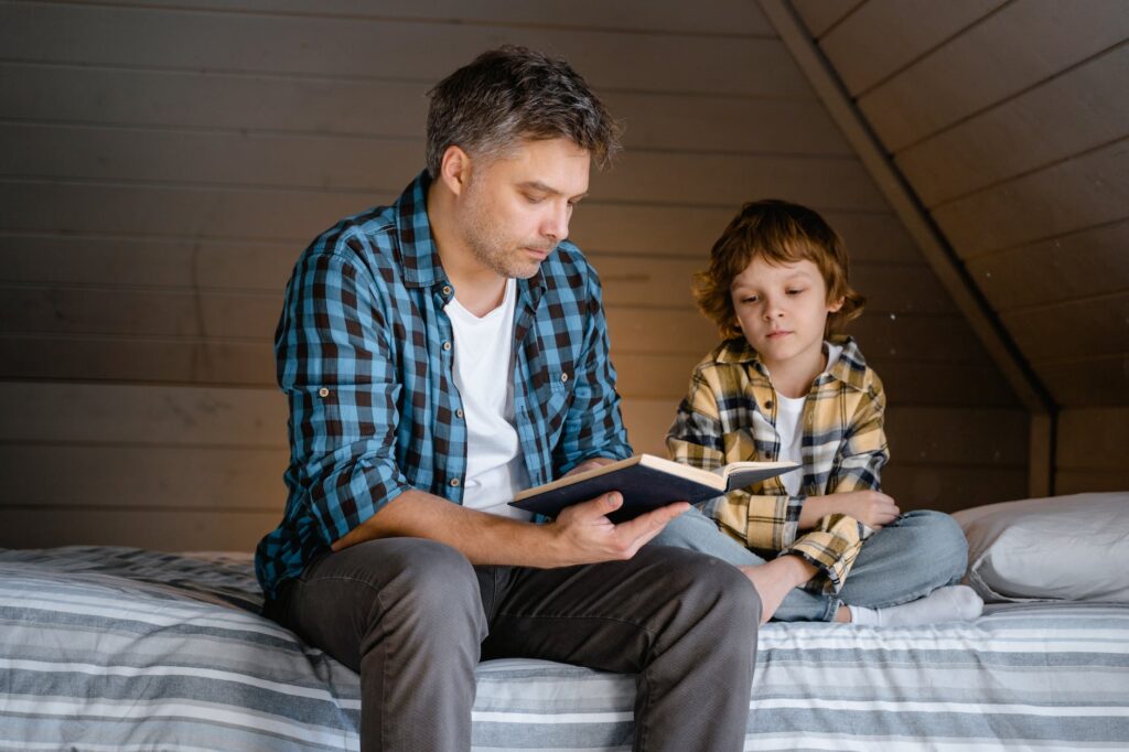 a man and boy reading a book together